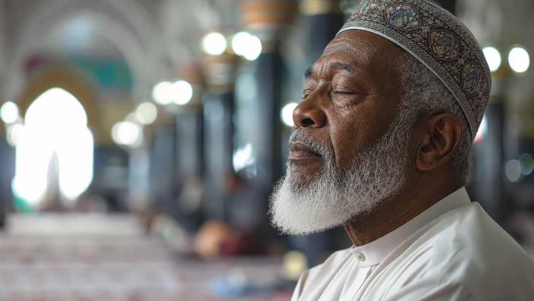 An elder in quiet reflection inside a masjid
